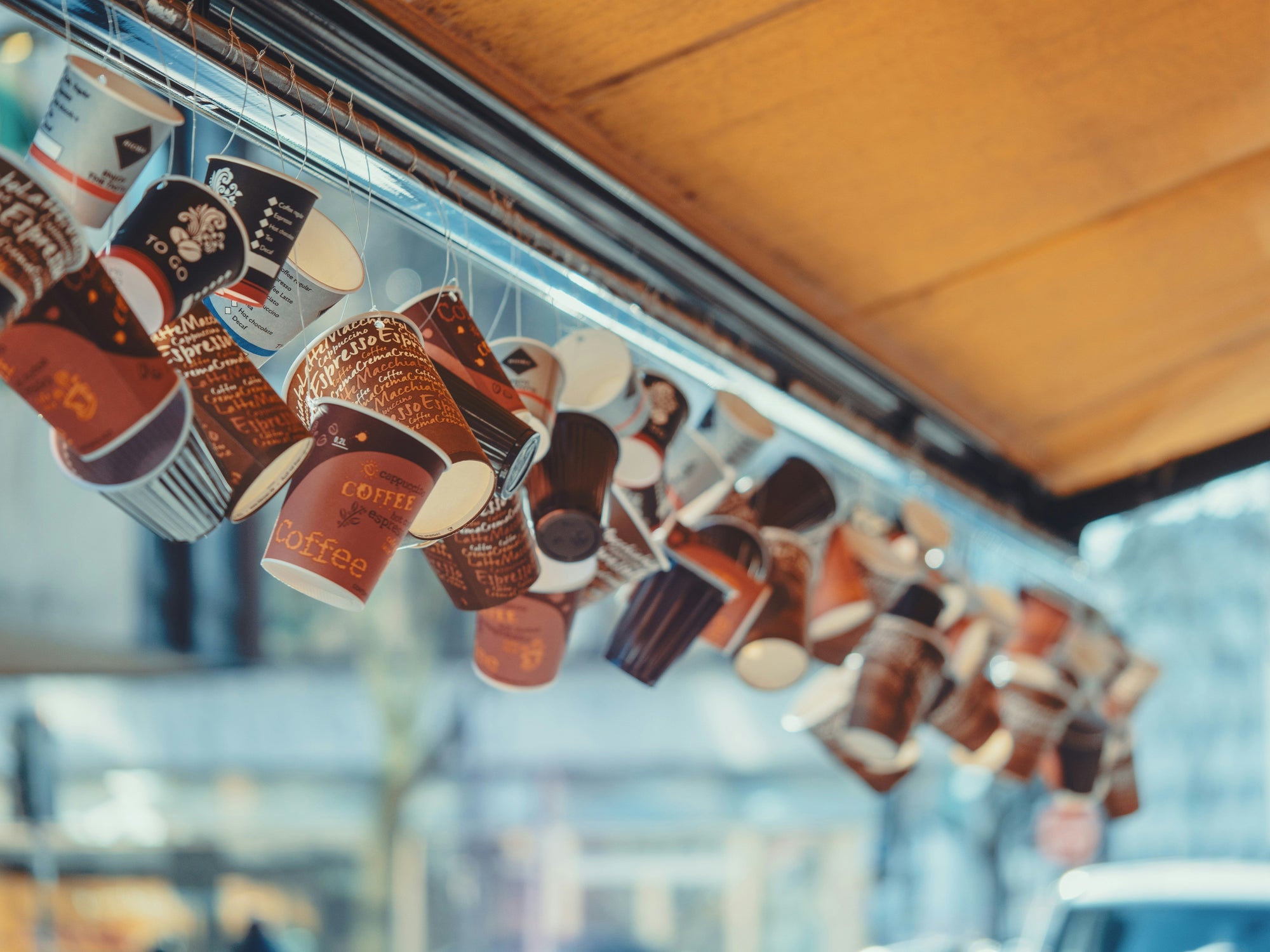 Dangling paper cups from an over hang, photo by Daniel von Appen on Unsplash
