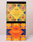 Two coffee tour boxes with colorful designs and text on a beige background showcased coffee from women farmers in two key coffee regions.