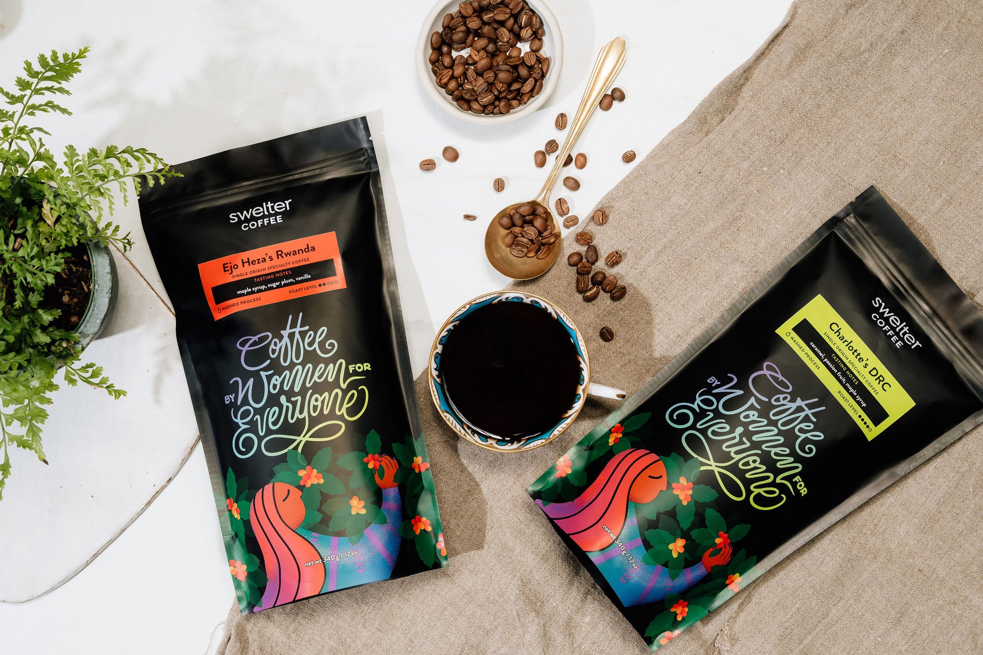 Overhead shot of Swelter Coffee bags showcasing women coffee producers in Rwanda and the DRC, on a white table with decorative elements around.