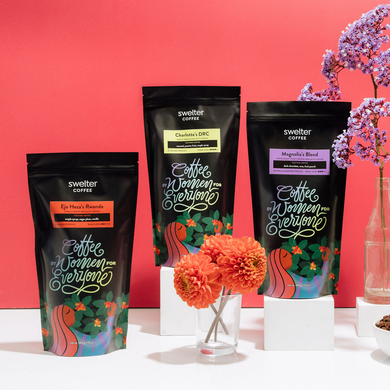 Three coffee bags of Swelter Coffee featuring women coffee producers on a white surface against a magenta background